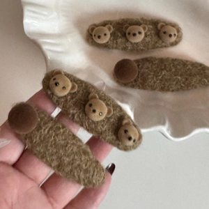 Détail de pinces à cheveux ours en peluche marron avec texture laine et design mignon