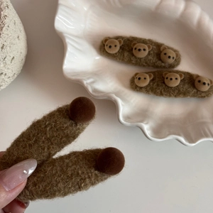 Détail des barrettes ours en peluche marron doux avec une texture duveteuse pour l'hiver
