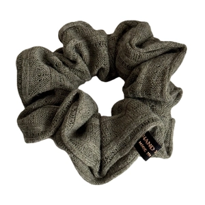 Olive green knitted scrunchie with striped texture and handmade label for bun styling