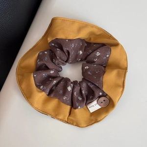 Close-up of vintage floral hair scrunchie with mustard yellow fabric and wooden button