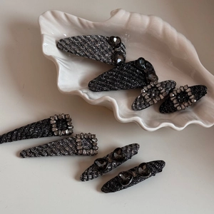 Set of 8 elegant black tweed BB hair clips with rhinestones and heart gems on a white tray