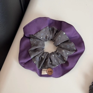 Detail of floral patchwork scrunchie with wooden button and handmade label texture