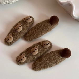 Vue détaillée de quatre barrettes ours en peluche marron avec texture en fausse fourrure