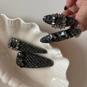 Detailed close-up of premium black fabric hair clips with sparkling grey crystals in a set