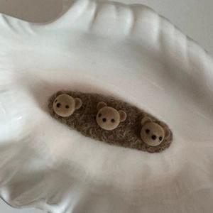 Gros plan d'une barrette ours en peluche marron montrant la texture douce sur une assiette