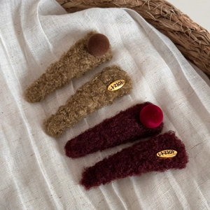 Lot de quatre barrettes en peluche bouclée marron foncé et bordeaux avec étiquettes dorées