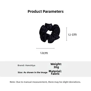Detailed view of black polka dot fabric scrunchie with 12cm diameter measurement