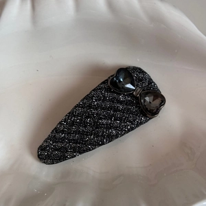 Detail of water-drop BB hair clip with black glitter fabric and heart-shaped crystals