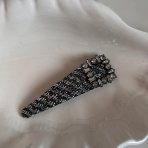 Macro view of triangle hair clip with sparkling silver fabric and rhinestone frame decoration