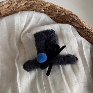 Dettaglio mini fermaglio per capelli cappello floccato nero con pompon blu e fiocco