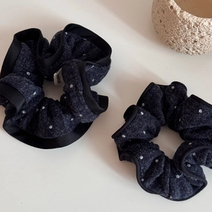 Macro detail of handmade polka dot knit scrunchies with satin edges and woven label