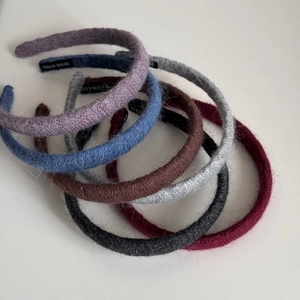 Detail of multi-color knitted headbands showing textured yarn and Hand Made woven labels