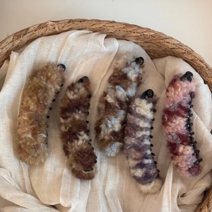 Vista dettagliata di cinque fermagli a banana in peluche colorati in un cesto