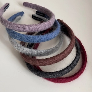 Close-up of six-color handmade knit hairbands with fuzzy mohair texture and HANDMADE label