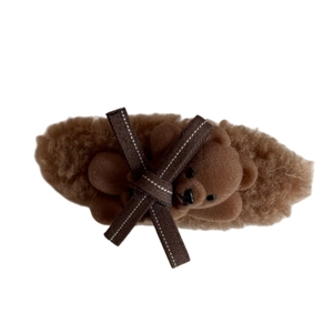 Brown fuzzy hair clip with plush bear and ribbon bow on a clean white background