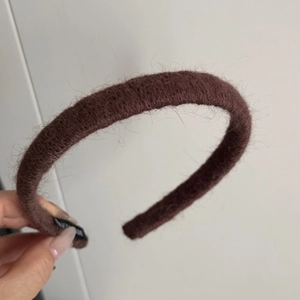 Close-up of handmade label on fuzzy brown knit headband with plush velvet texture