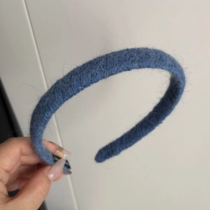 Detailed view of blue knitted headband featuring fuzzy mohair texture and warm winter fabric