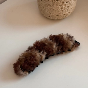 Dettaglio del fermaglio per capelli a banana in morbido peluche marrone con pelliccia sintetica
