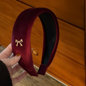Close-up of wine red velvet wide headband with gold butterfly accent and non-slip lining