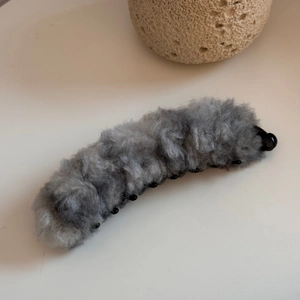 Vista dettagliata della clip a banana in morbido peluche grigio con pettine di tenuta