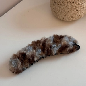 Dettaglio della clip a banana in peluche con pelliccia sintetica e denti interni solidi