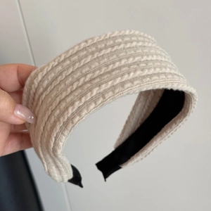 Detalle de diadema de punto trenzado blanco crudo con textura y forro interior negro