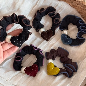Dettaglio di elastici a cuore in velluto con perle bianche e bordi ondulati in set