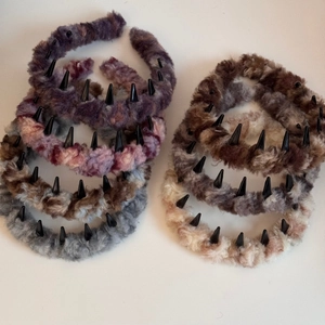 Plush faux fur headbands with black punk spikes in various colors on white background