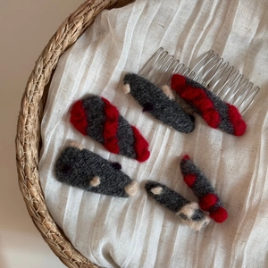 Vue détaillée de pinces à cheveux et peignes en feutre faits main en gris et rouge