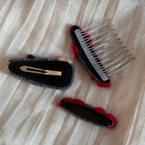 Ensemble de trois barrettes en feutre gris et rouge sur un tissu en lin texturé