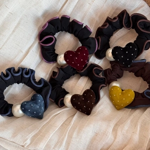 Dettaglio dei ciondoli a cuore in velluto a pois e grandi perle su elastici scrunchie