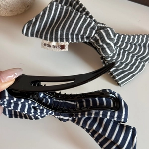 Detail view of the cotton striped bow hair clip interior with dense teeth for strong grip