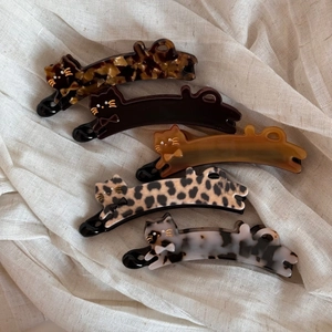 Detailed macro view of cat-shaped acetate banana clips with elegant leopard and amber patterns