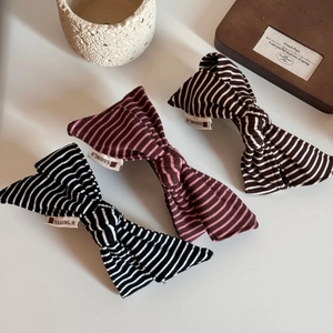 Three oversized striped fabric bow hair clips in black, purple, and brown colors