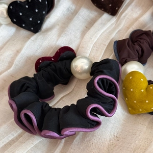 Dettaglio di elastici a cuore floccati con perle finte e texture in pizzo elegante
