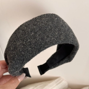 Détail d'un serre-tête en peluche gris foncé avec texture laine épaisse pour l'automne