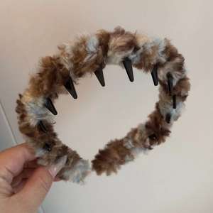 Detailed view of plush leopard print headband with non-slip inner teeth for winter