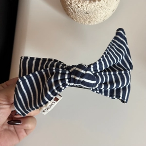 Close-up of blue and white striped fabric bow hair clip with SAVING.R woven label