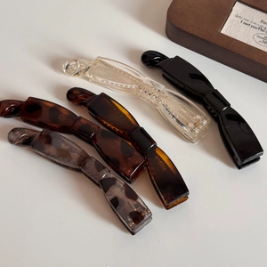 Détail de quatre barrettes bananes en résine : noir, transparent, écaille et motif léopard