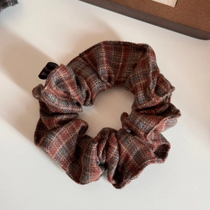 Detailed close-up of retro plaid wool scrunchie featuring vintage checkered fabric texture