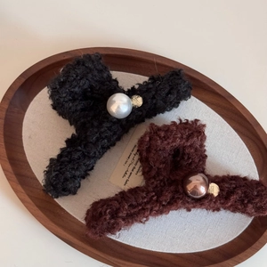 Detail of plush faux fur hair claws in black and brown with pearls and gold charms