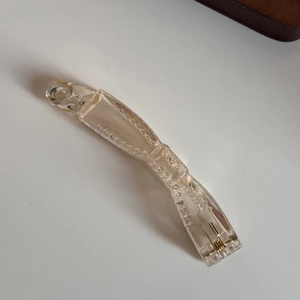 Détail d'une pince banane en résine doré champagne avec texture perlée et ressort en métal