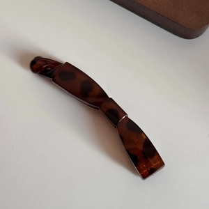 Détail de la pince banane écaille de tortue en résine polie pour une tenue parfaite