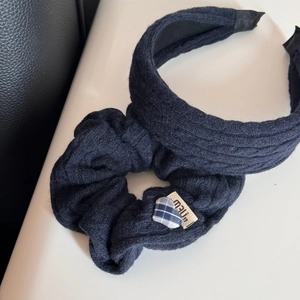 Dettaglio del set fascia in maglia a trecce blu scuro con elastico con motivo a cuore