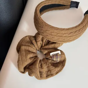 Dettaglio della trama della fascia e dell'elastico in maglia caramello con cuore