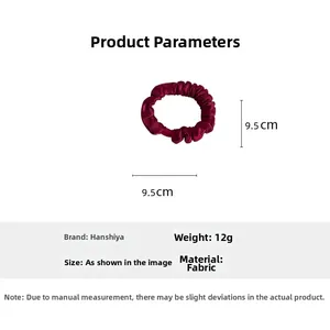 Detail view of festive red fabric scrunchie with pleated texture and 9.5cm size dimension