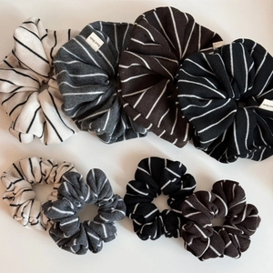 Vue détaillée de chouchous tricotés à rayures de tailles variées en beige, gris et café