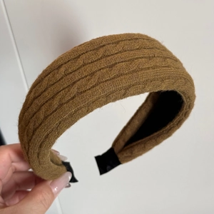 Dettaglio della fascia per capelli marrone a maglia con fodera antiscivolo