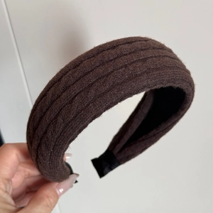 Dettaglio di una fascia in maglia marrone scuro con trama a coste e fodera interna antiscivolo