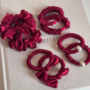 Set of burgundy satin scrunchies and elastic hair ties with metallic beads and bow accents